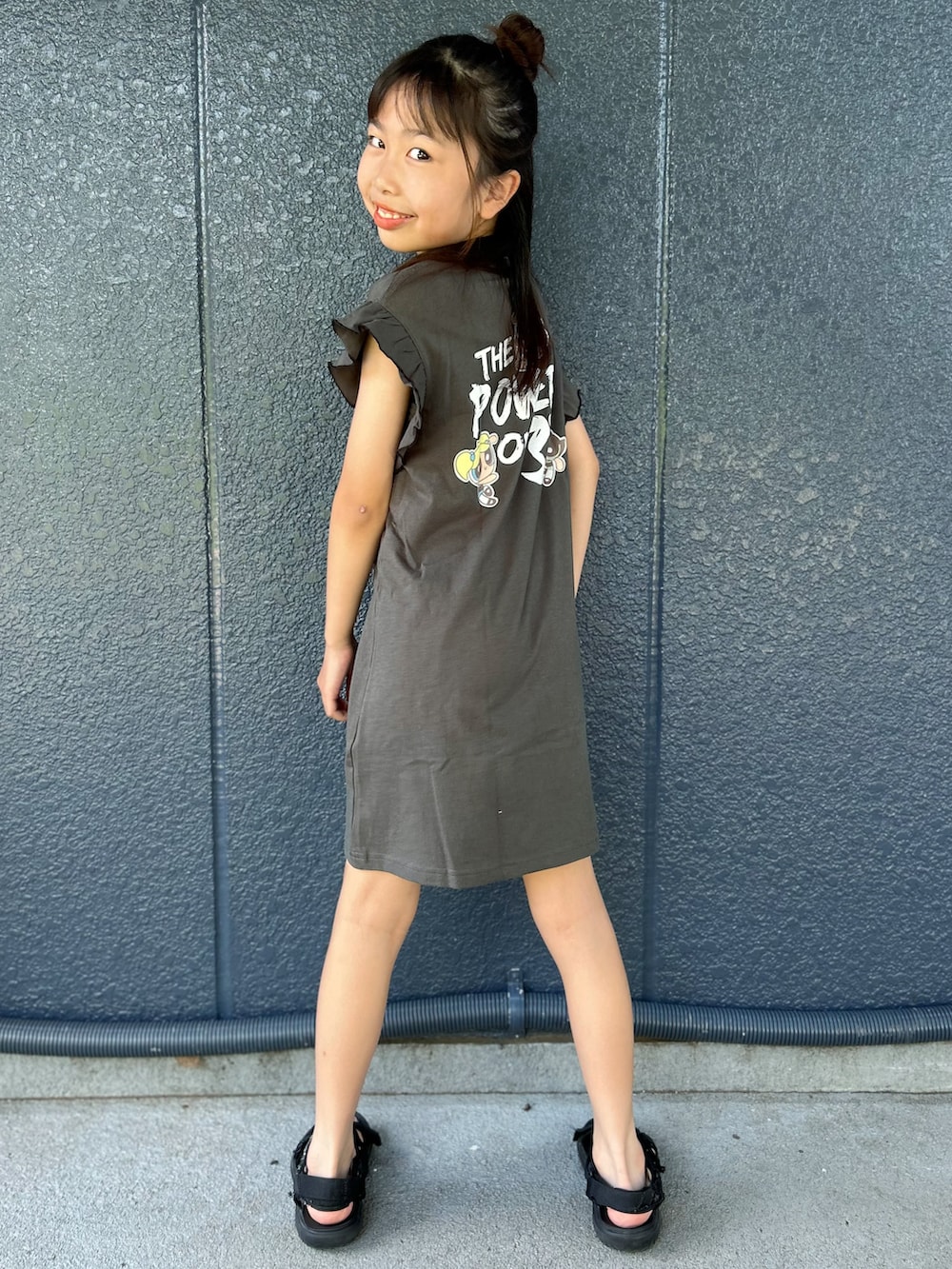 ブラック系のワンピース、ブラック系のショルダーバッグを着用したキッズの夏コーディネートの4枚目の写真