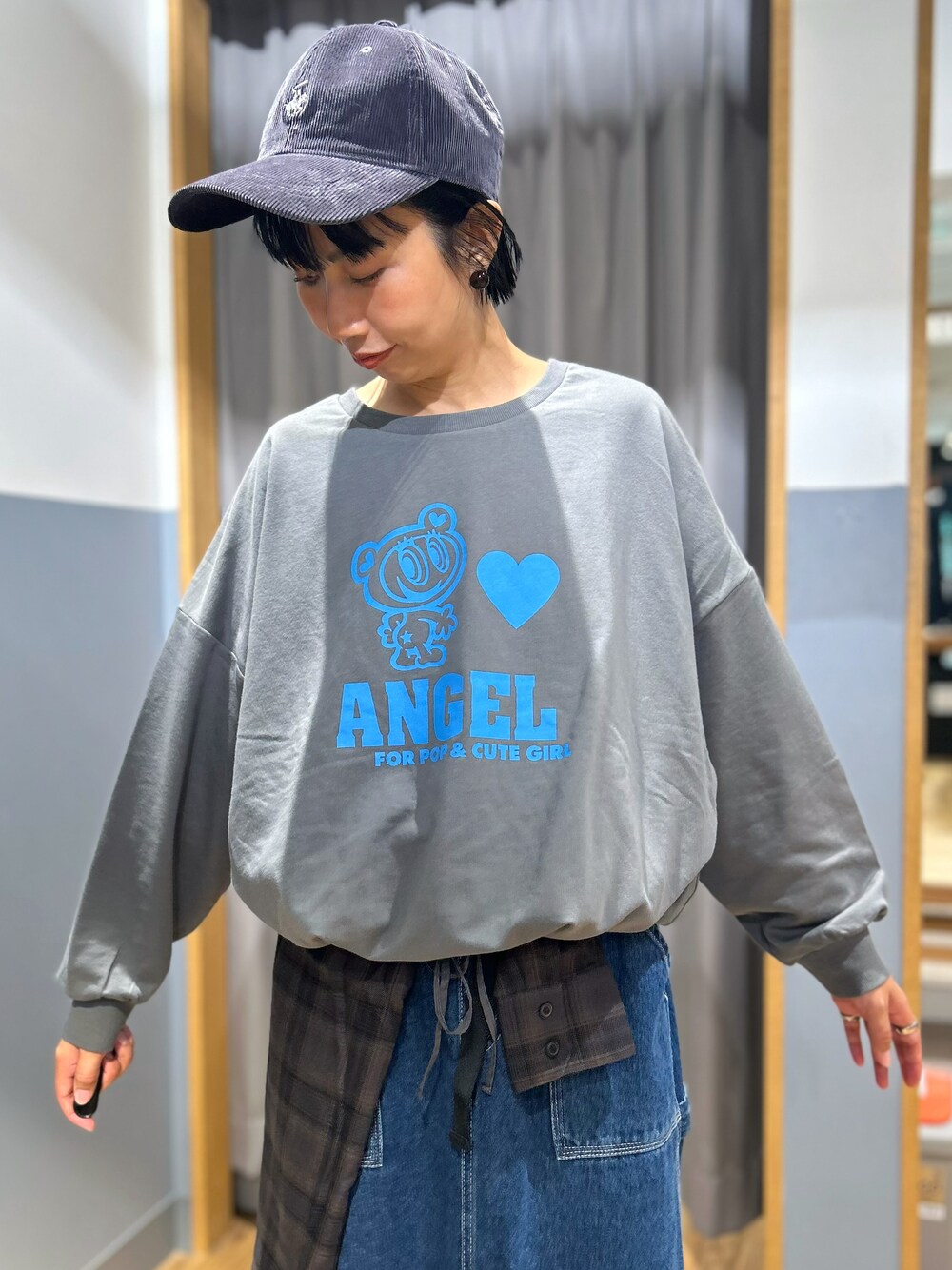 グレー系のニット/セーター、ブルー系のスカート、ブラック系のボストンバッグを着用したレディースの秋コーディネートの5枚目の写真