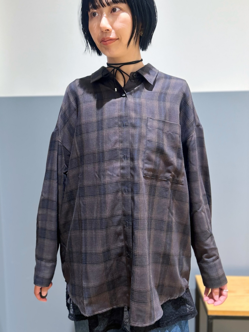 ブラウン系のシャツ/ブラウス、ブラック系のタンクトップ、ブルー系のデニムパンツを着用したレディースの秋コーディネートの4枚目の写真