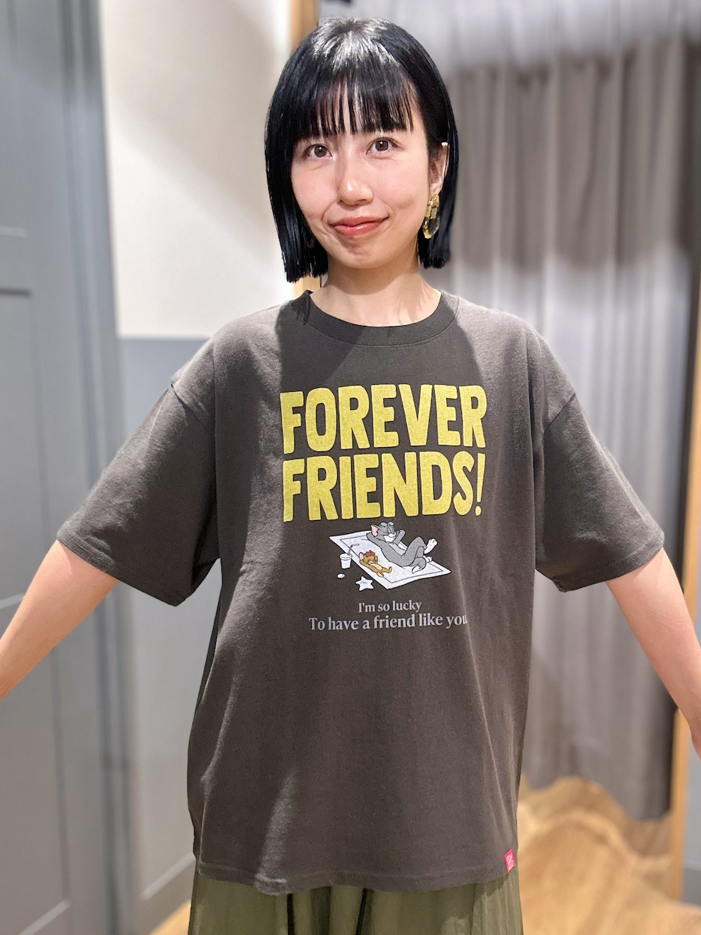 グレー系のTシャツ/カットソー、グリーン系のスカート、ブラック系のショルダーバッグを着用したレディースの夏コーディネートの4枚目の写真