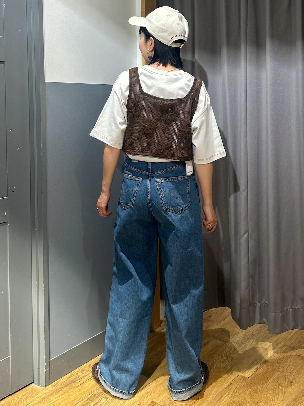 ホワイト系のTシャツ/カットソー、ブルー系のデニムパンツ、ブラウン系のベストを着用したレディースの春コーディネートの3枚目の写真
