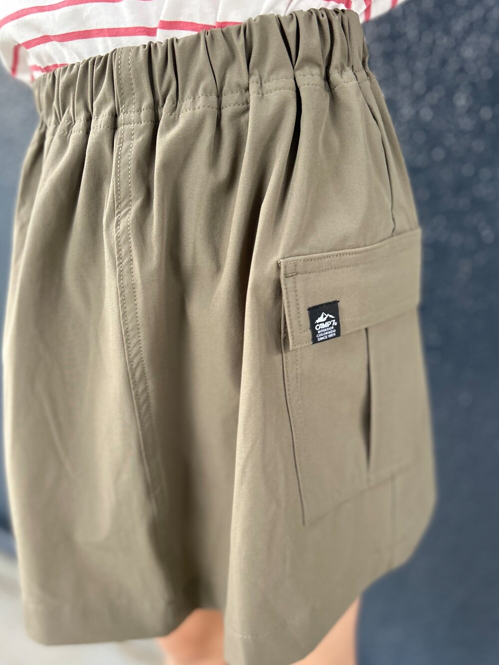 レッド系のTシャツ/カットソー、ブラウン系のスカート、ベージュ系のキャップを着用したキッズの夏コーディネートの5枚目の写真