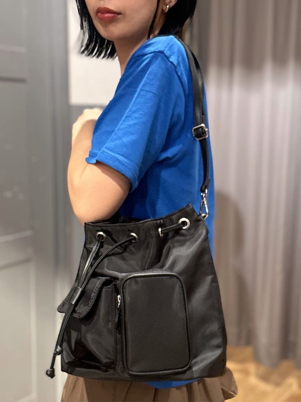 ブルー系のTシャツ/カットソー、ブラウン系のスカート、ベージュ系のシャツ/ブラウスを着用したレディースの春コーディネートの10枚目の写真