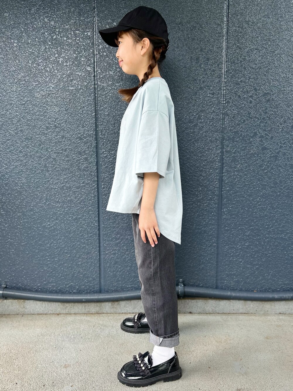 ブルー系のTシャツ/カットソー、ブラック系のデニムパンツ、ブラック系のキャップを着用したレディースの春コーディネートの2枚目の写真