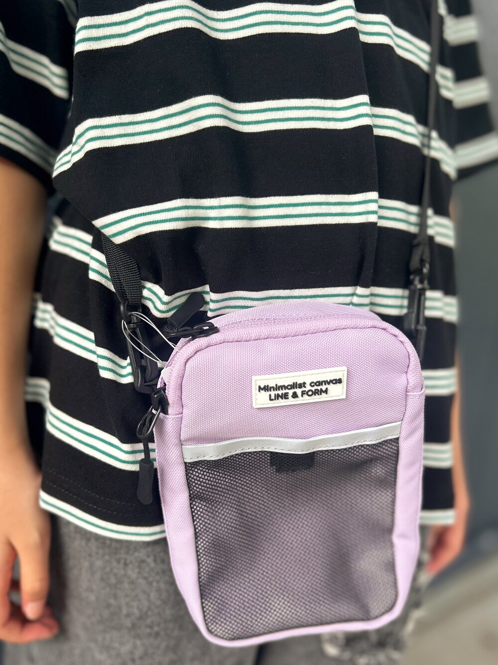 グレー系のTシャツ/カットソー、ブラック系のその他パンツ、パープル系のショルダーバッグを着用したキッズの秋コーディネートの7枚目の写真