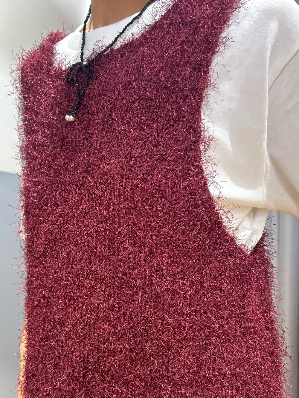 ホワイト系のTシャツ/カットソー、レッド系のベスト、ブルー系のその他パンツを着用したレディースの秋コーディネートの5枚目の写真