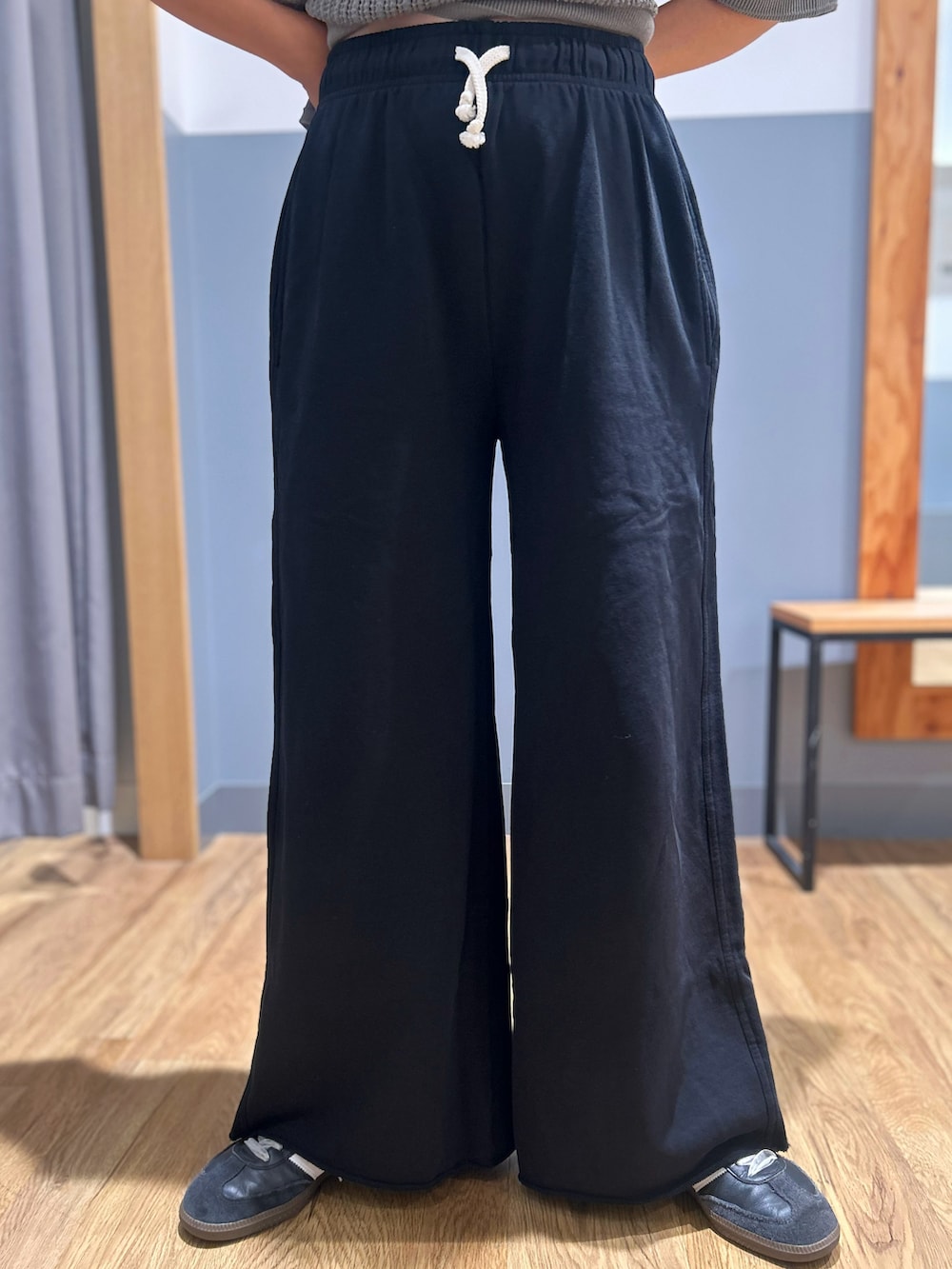 グレー系のニット/セーター、ブラック系のその他パンツ、ブラック系のショルダーバッグを着用したレディースの秋コーディネートの6枚目の写真