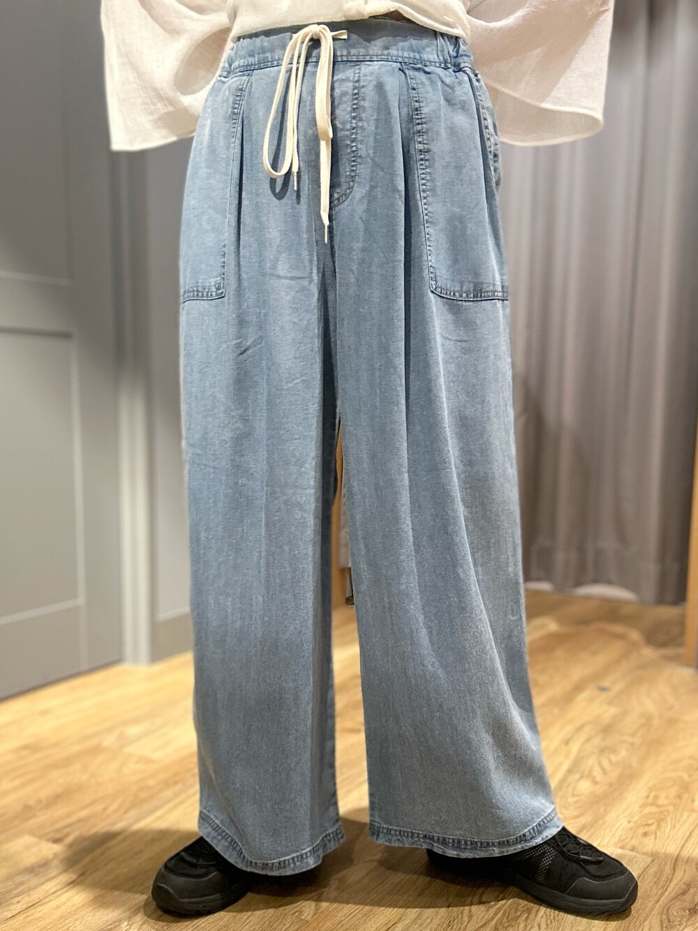 ベージュ系のタンクトップ、ホワイト系のシャツ/ブラウス、ブルー系のデニムパンツを着用したレディースの夏コーディネートの9枚目の写真