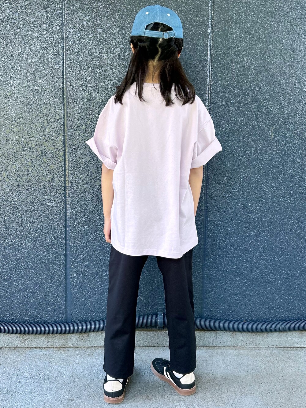 ピンク系のTシャツ/カットソー、ブラック系のその他パンツ、ブルー系のキャップを着用したレディースの春コーディネートの4枚目の写真