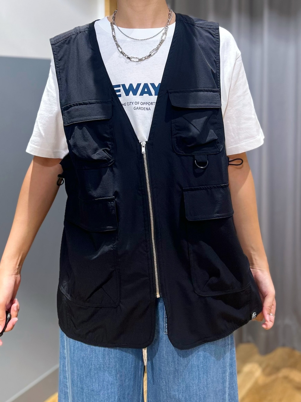 ホワイト系のTシャツ/カットソー、ブルー系のデニムパンツ、ブラック系のシャツ/ブラウスを着用したレディースの夏コーディネートの4枚目の写真