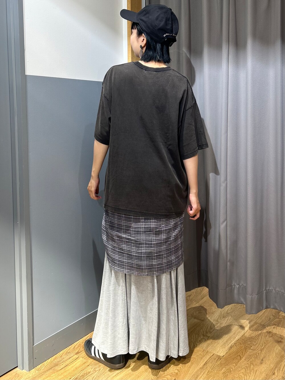 グレー系のスカート、グレー系のシャツ/ブラウス、ブラック系のキャップを着用したレディースの夏コーディネートの3枚目の写真