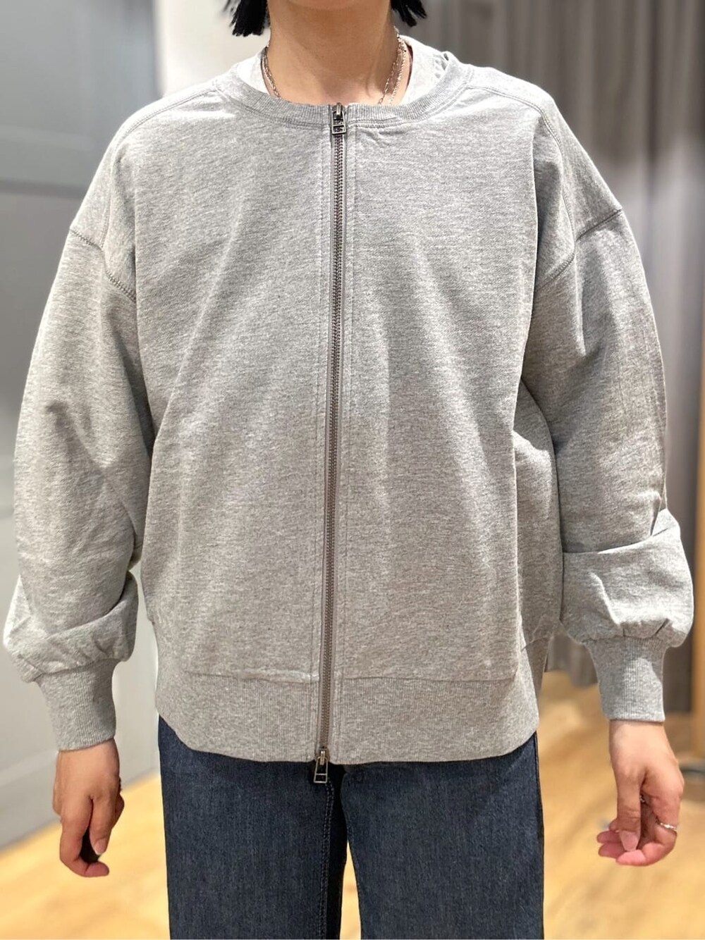 グレー系のTシャツ/カットソー、グレー系のカーディガン/ボレロ、ブルー系のデニムパンツを着用したレディースの春コーディネートの4枚目の写真