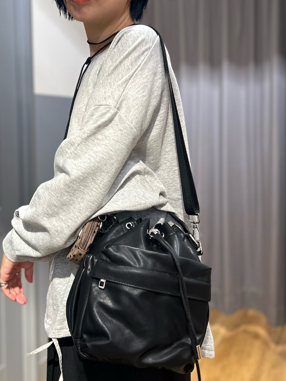 グレー系のニット/セーター、ブラック系のショルダーバッグ、ブラック系のその他パンツを着用したレディースの秋コーディネートの10枚目の写真