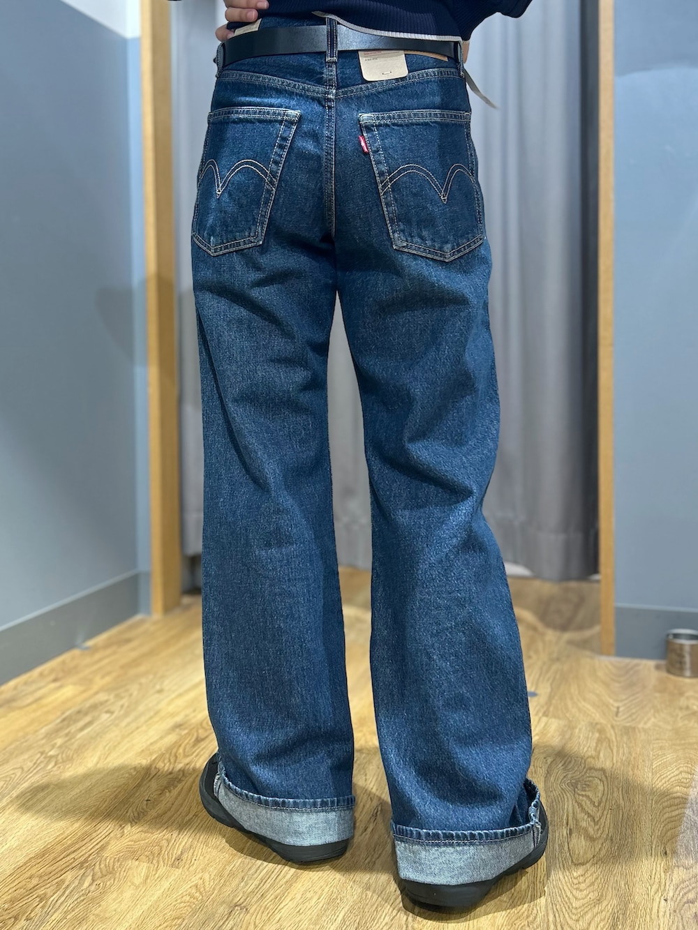 ブルー系のニット/セーター、ブルー系のデニムパンツ、グリーン系のショルダーバッグを着用したレディースの秋コーディネートの6枚目の写真