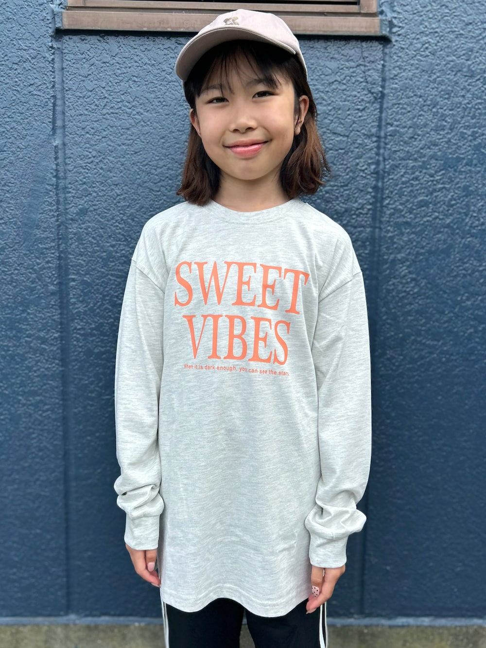 ブラック系のその他パンツ、ホワイト系のTシャツ/カットソー、ベージュ系のキャップを着用したキッズの秋コーディネートの4枚目の写真