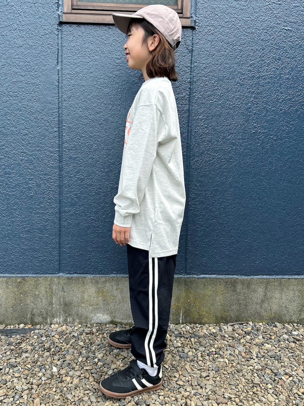 ブラック系のその他パンツ、ホワイト系のTシャツ/カットソー、ベージュ系のキャップを着用したキッズの秋コーディネートの2枚目の写真