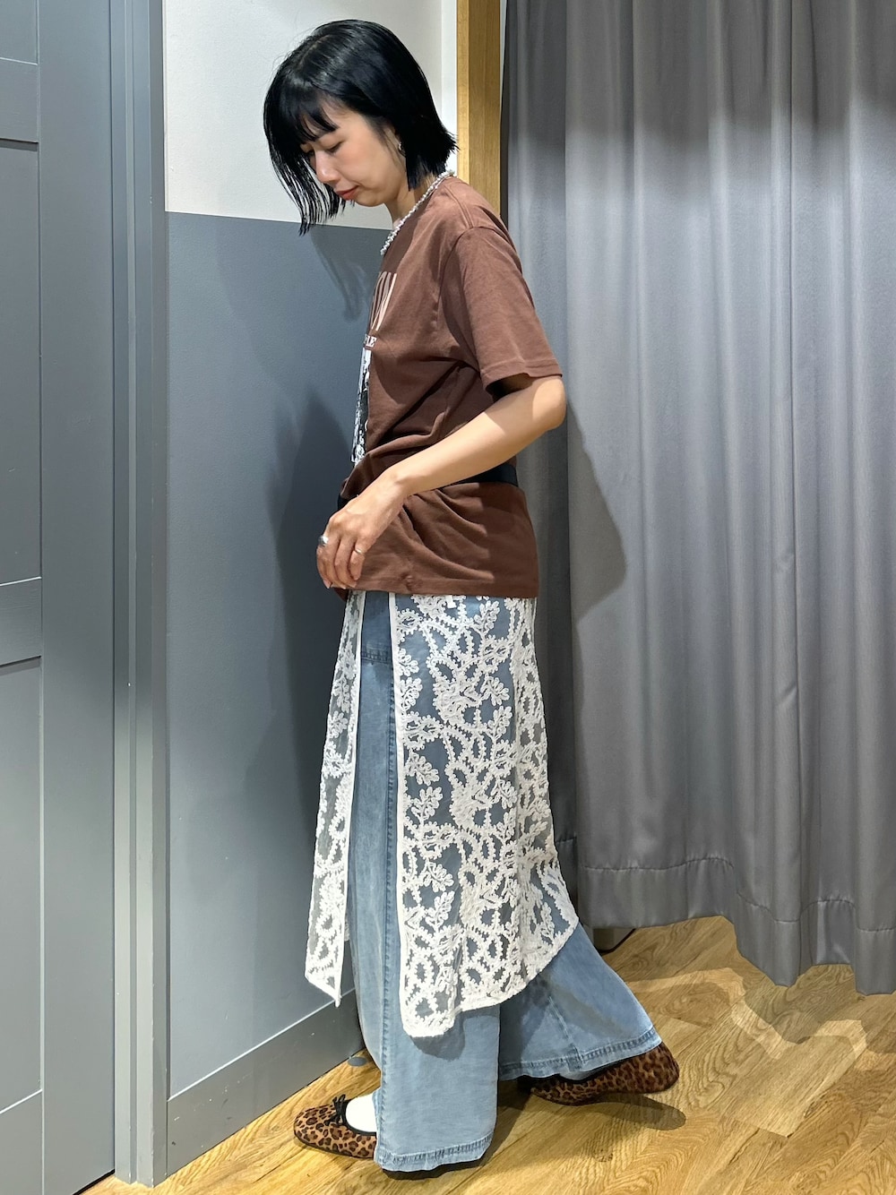 ブラウン系のTシャツ/カットソー、ブルー系のデニムパンツ、ホワイト系のスカートを着用したレディースの夏コーディネートの2枚目の写真