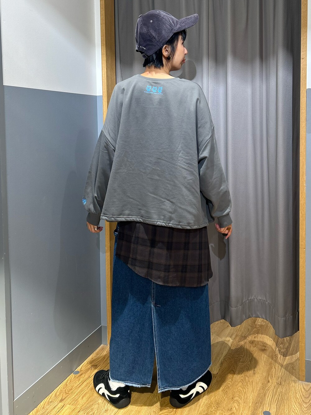 グレー系のニット/セーター、ブルー系のスカート、ブラック系のボストンバッグを着用したレディースの秋コーディネートの3枚目の写真