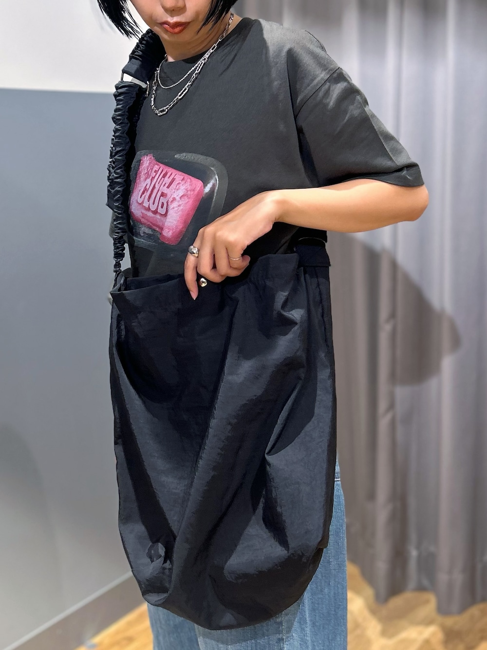 グレー系のTシャツ/カットソー、ブルー系のデニムパンツ、ブラック系のショルダーバッグを着用したレディースの夏コーディネートの9枚目の写真