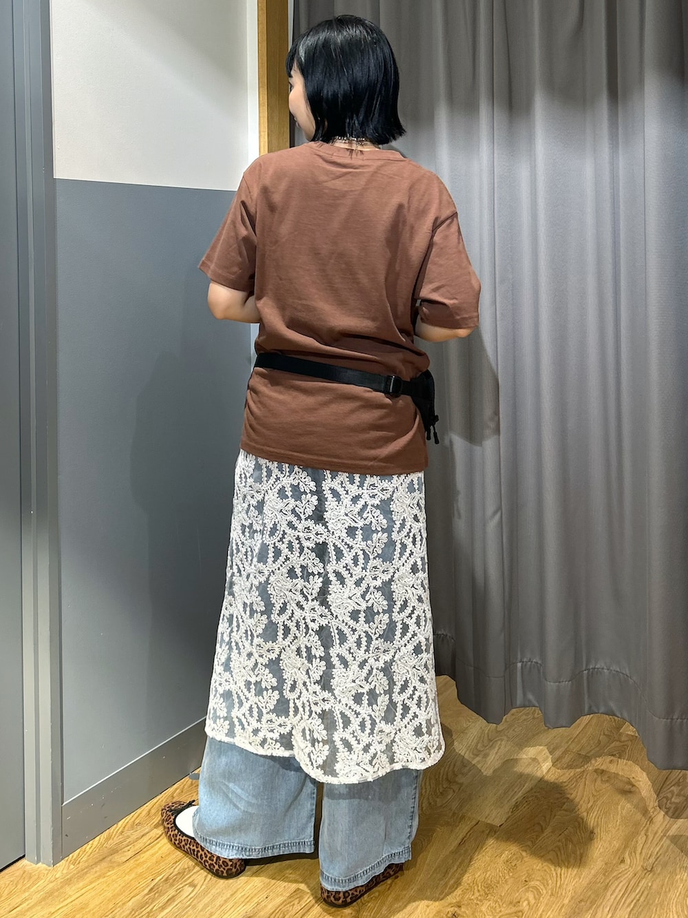 ブラウン系のTシャツ/カットソー、ブルー系のデニムパンツ、ホワイト系のスカートを着用したレディースの夏コーディネートの3枚目の写真