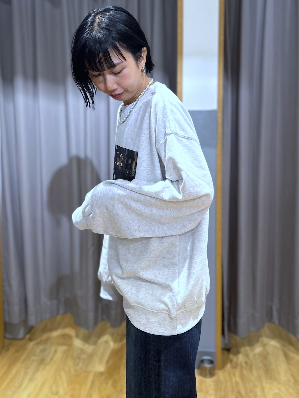 ベージュ系のスウェット、ホワイト系のTシャツ/カットソー、ブルー系のデニムパンツを着用したレディースの秋コーディネートの5枚目の写真