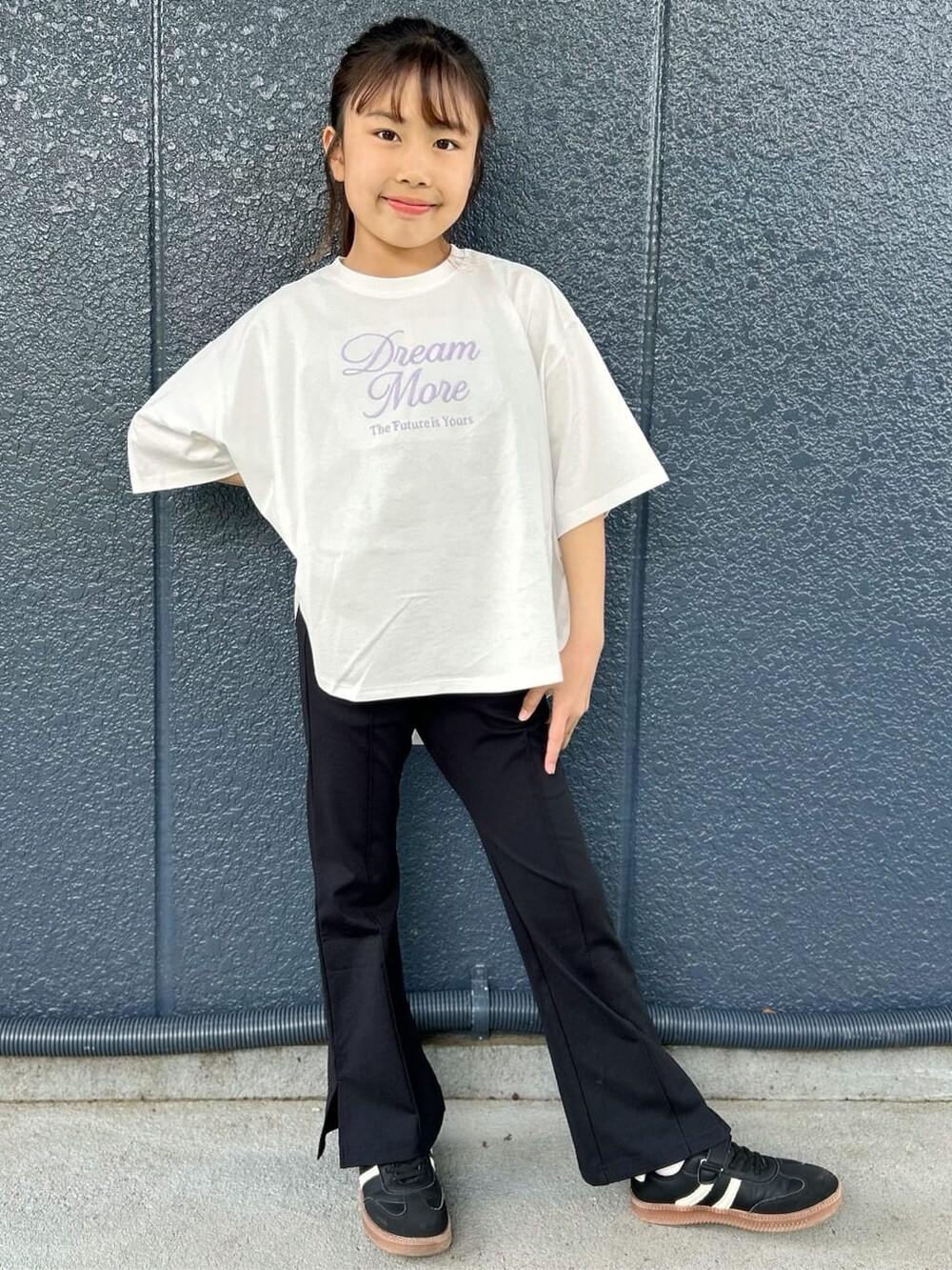ホワイト系のTシャツ/カットソー、ブラック系のその他パンツ、シルバー系のショルダーバッグを着用したキッズの春コーディネートの2枚目の写真