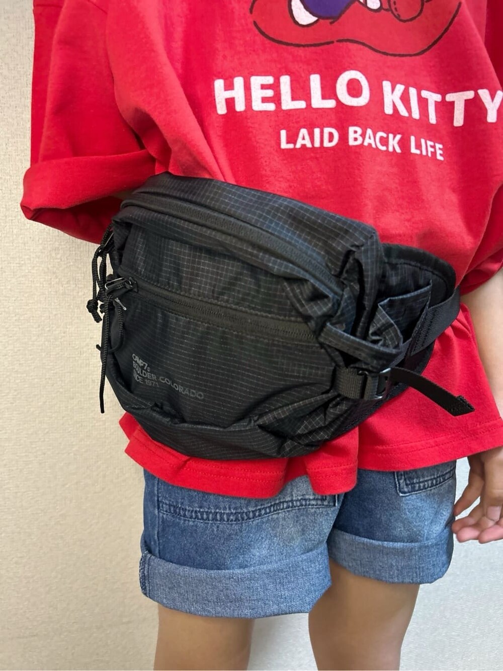 レッド系のTシャツ/カットソー、ブルー系のその他パンツ、ブラック系のボディバッグ/ウエストポーチを着用したキッズの春コーディネートの8枚目の写真