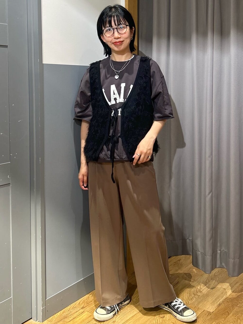 グレー系のTシャツ/カットソー、ブラック系のベスト、ブラック系のその他を着用したレディースの春コーディネートの2枚目の写真