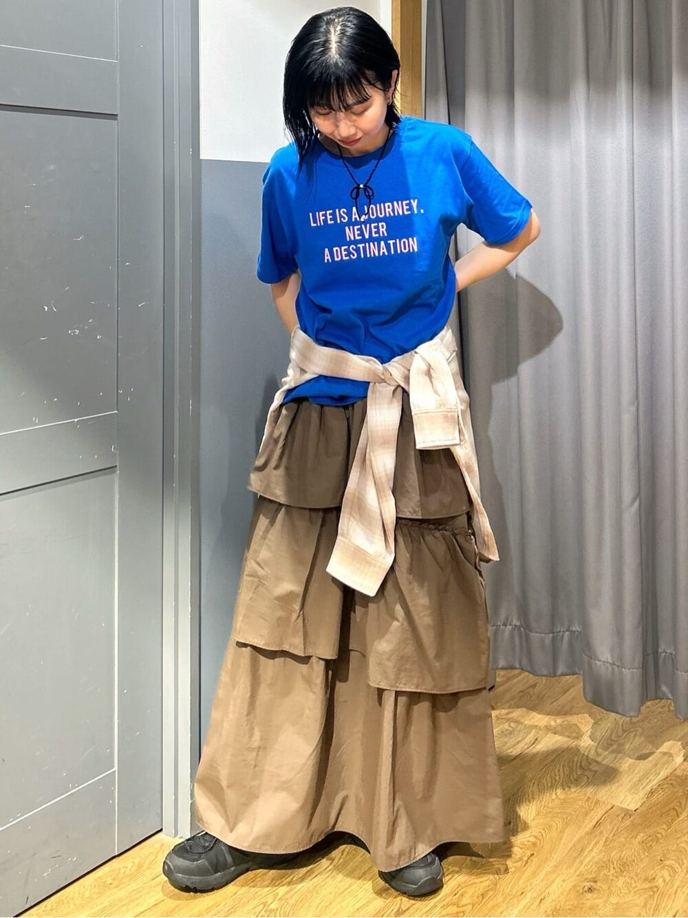 ブルー系のTシャツ/カットソー、ブラウン系のスカート、ベージュ系のシャツ/ブラウスを着用したレディースの春コーディネートの2枚目の写真