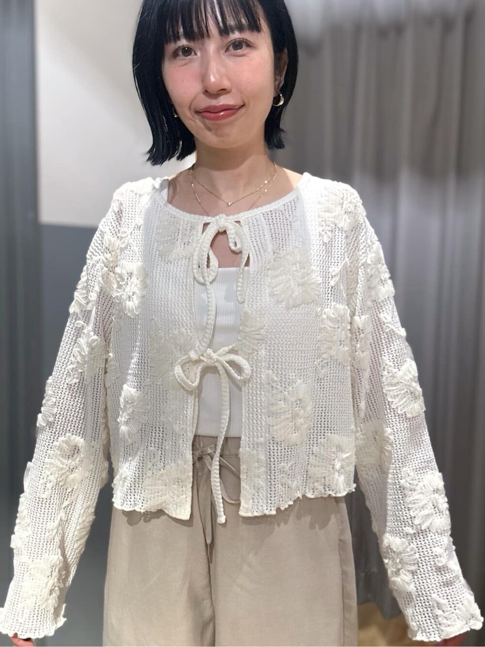 ホワイト系のカーディガン/ボレロ、ホワイト系のタンクトップ、ベージュ系のその他パンツを着用したレディースの春コーディネートの5枚目の写真