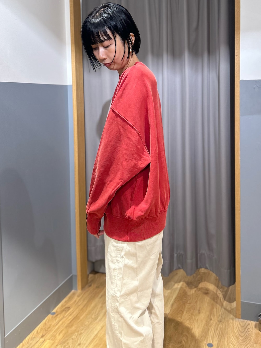 レッド系のスウェット、ホワイト系のその他パンツ、ブラウン系のバックパック/リュックを着用したレディースの秋コーディネートの2枚目の写真