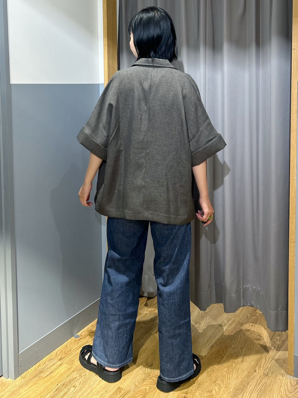 グレー系のテーラードジャケット、ホワイト系のタンクトップ、ブルー系のデニムパンツを着用したレディースの夏コーディネートの3枚目の写真