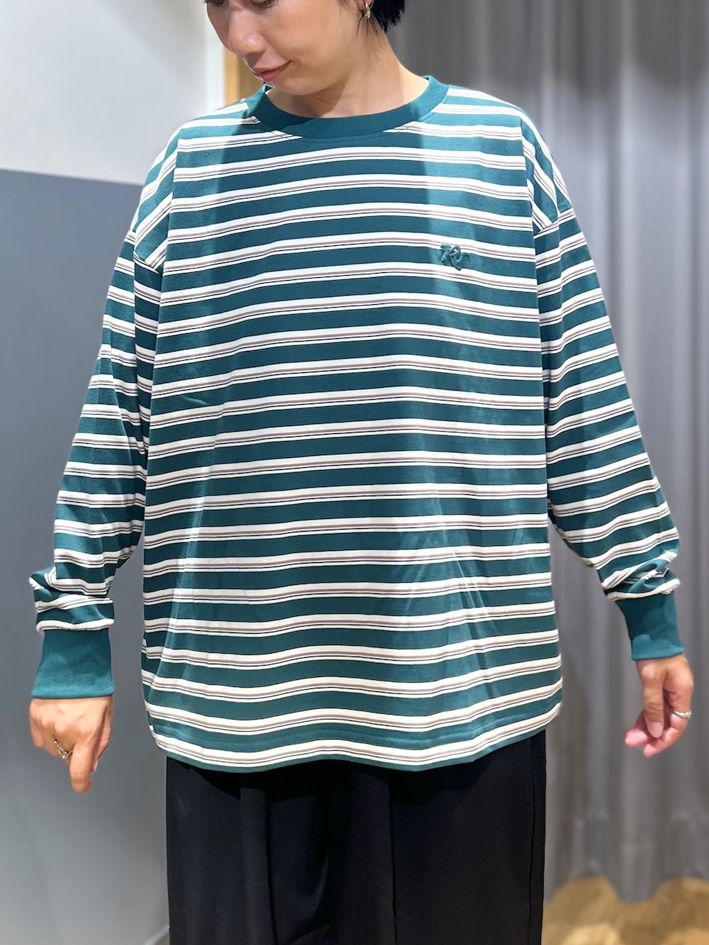 グリーン系のTシャツ/カットソー、ブラック系のその他パンツ、ブラック系のショルダーバッグを着用したレディースの秋コーディネートの4枚目の写真