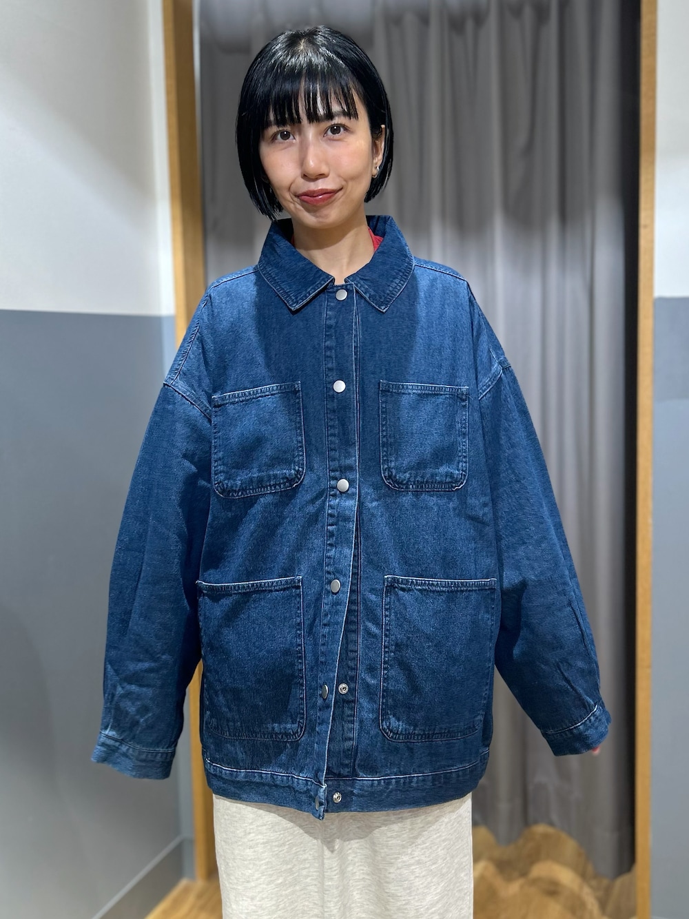 レッド系のスウェット、グレー系のスカート、ブルー系のシャツ/ブラウスを着用したレディースの秋コーディネートの4枚目の写真