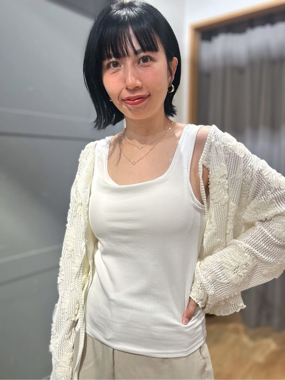 ホワイト系のカーディガン/ボレロ、ホワイト系のタンクトップ、ベージュ系のその他パンツを着用したレディースの春コーディネートの6枚目の写真