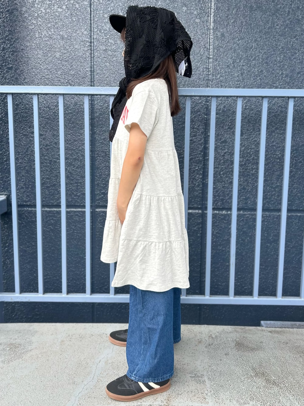 ブルー系のデニムパンツ、ホワイト系のルームワンピース、ブラック系のバンダナ/スカーフを着用したキッズの夏コーディネートの2枚目の写真