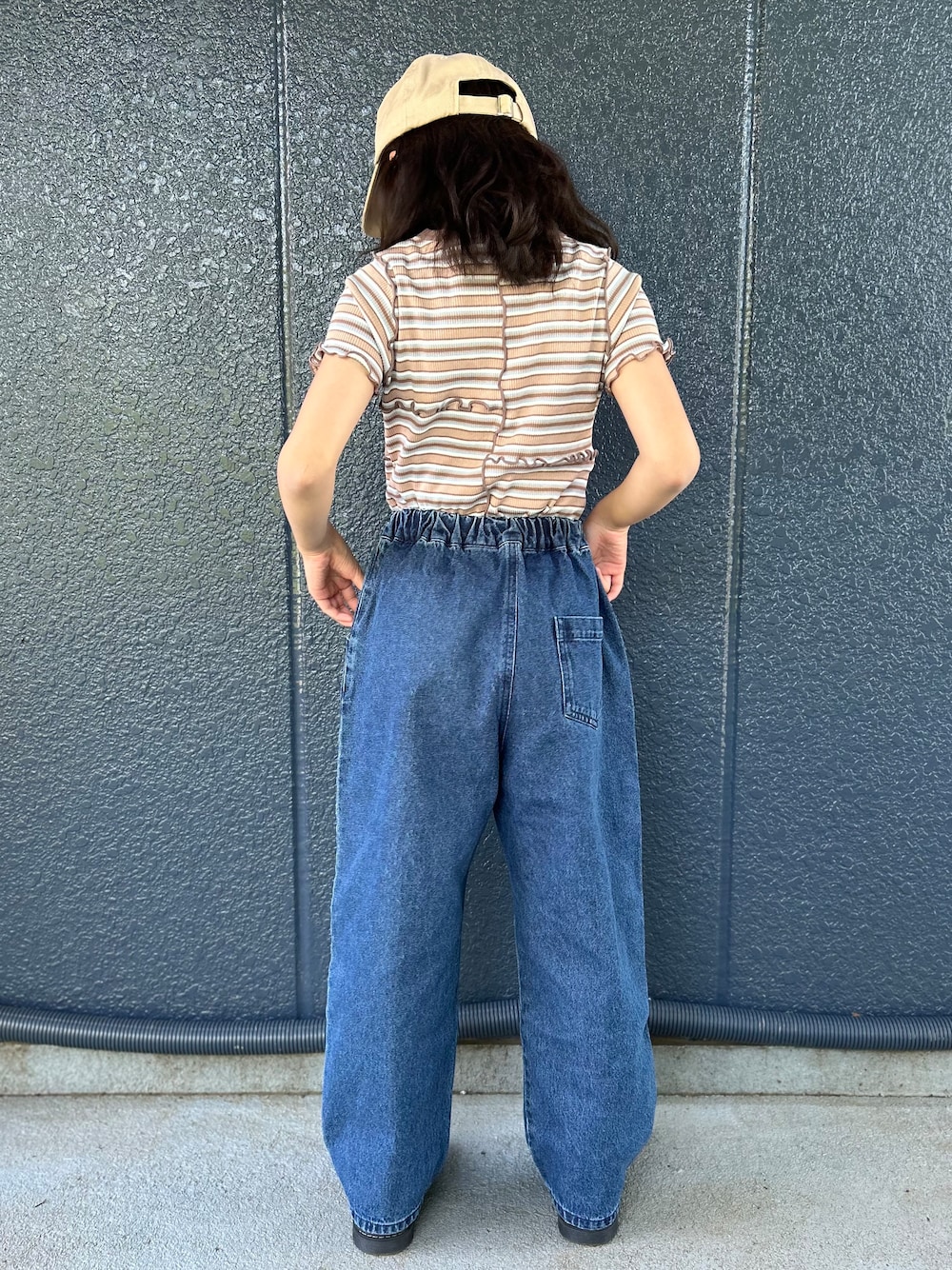 ブルー系のデニムパンツ、ブラウン系のTシャツ/カットソー、ベージュ系のキャップを着用したキッズの夏コーディネートの3枚目の写真