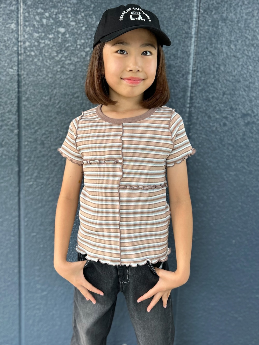 ブラウン系のTシャツ/カットソー、ブラック系のデニムパンツ、ブラック系のキャップを着用したキッズの夏コーディネートの4枚目の写真