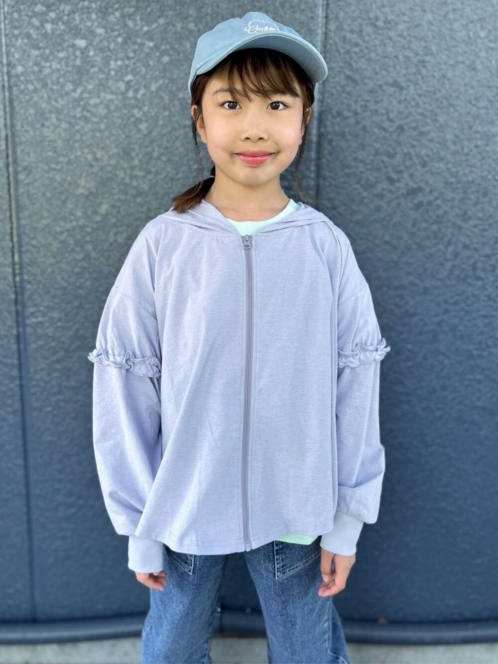グリーン系のTシャツ/カットソー、パープル系のパーカー、ブルー系のデニムパンツを着用したキッズの春コーディネートの7枚目の写真