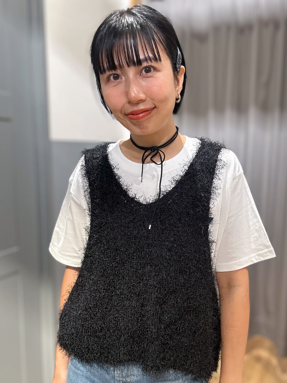 ホワイト系のTシャツ/カットソー、ブラック系のベスト、ブルー系のデニムパンツを着用したレディースの夏コーディネートの4枚目の写真