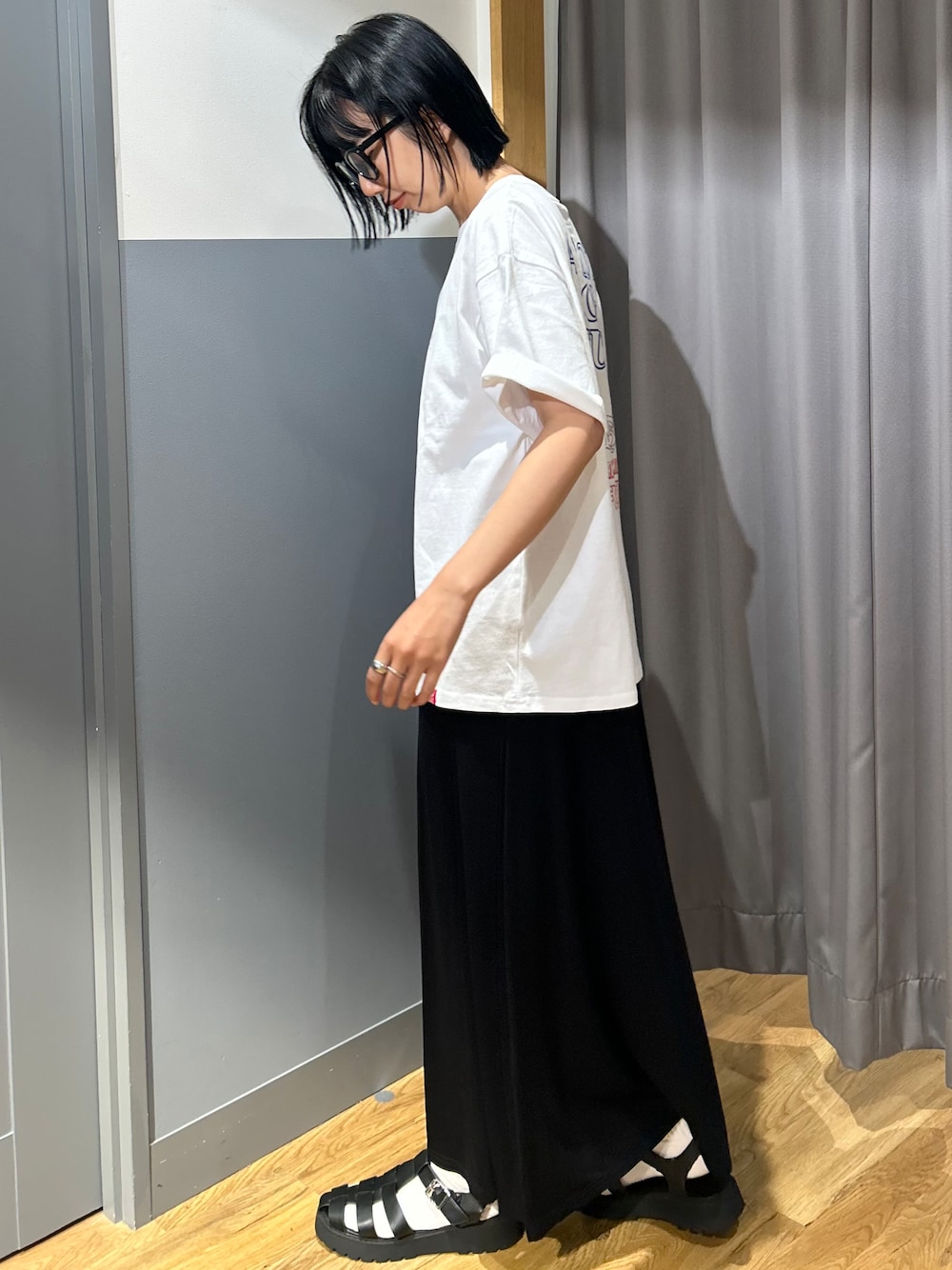ホワイト系のTシャツ/カットソー、ブラック系のスカート、ホワイト系のショルダーバッグを着用したレディースの夏コーディネートの3枚目の写真
