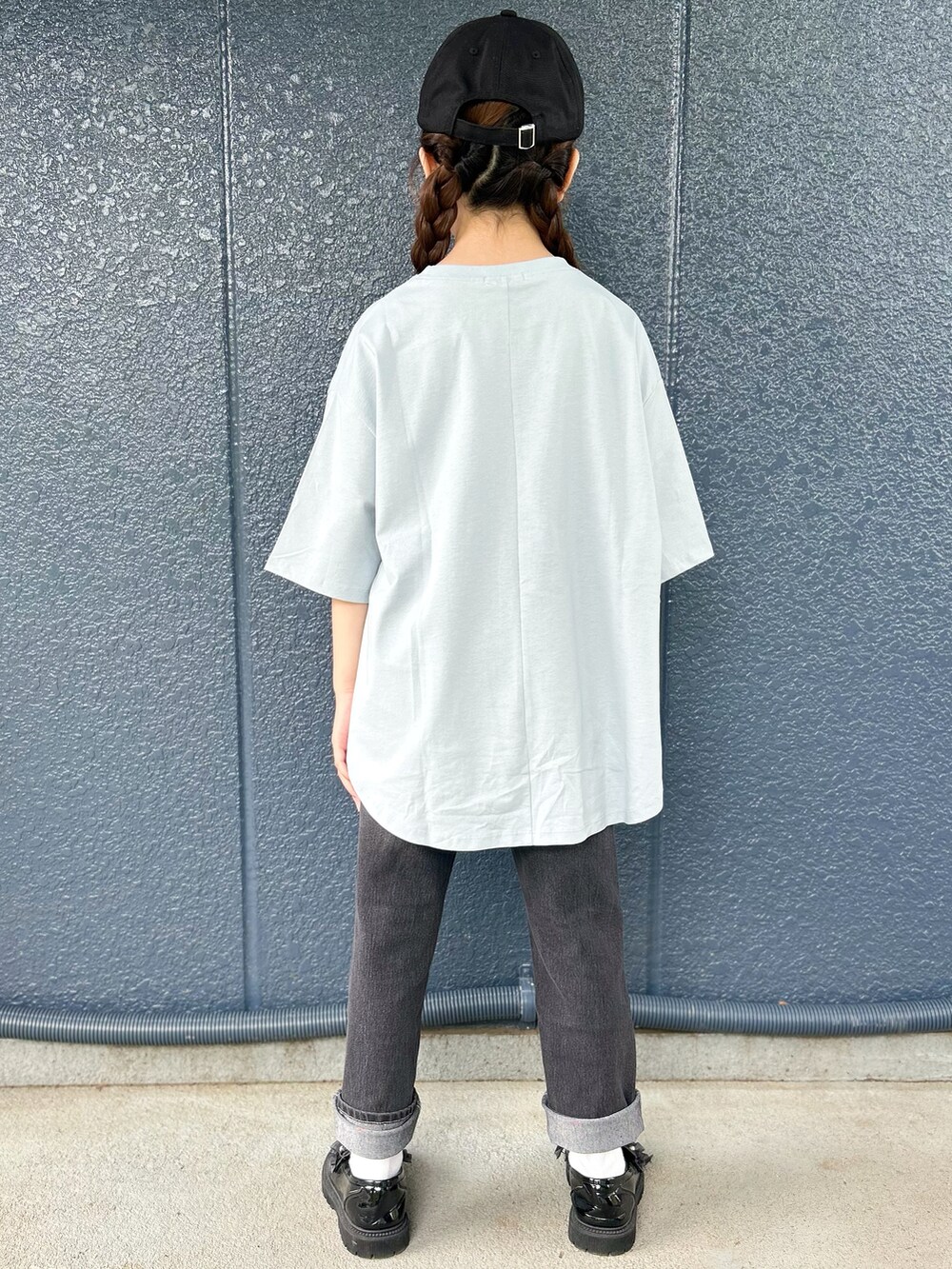 ブルー系のTシャツ/カットソー、ブラック系のデニムパンツ、ブラック系のキャップを着用したレディースの春コーディネートの3枚目の写真