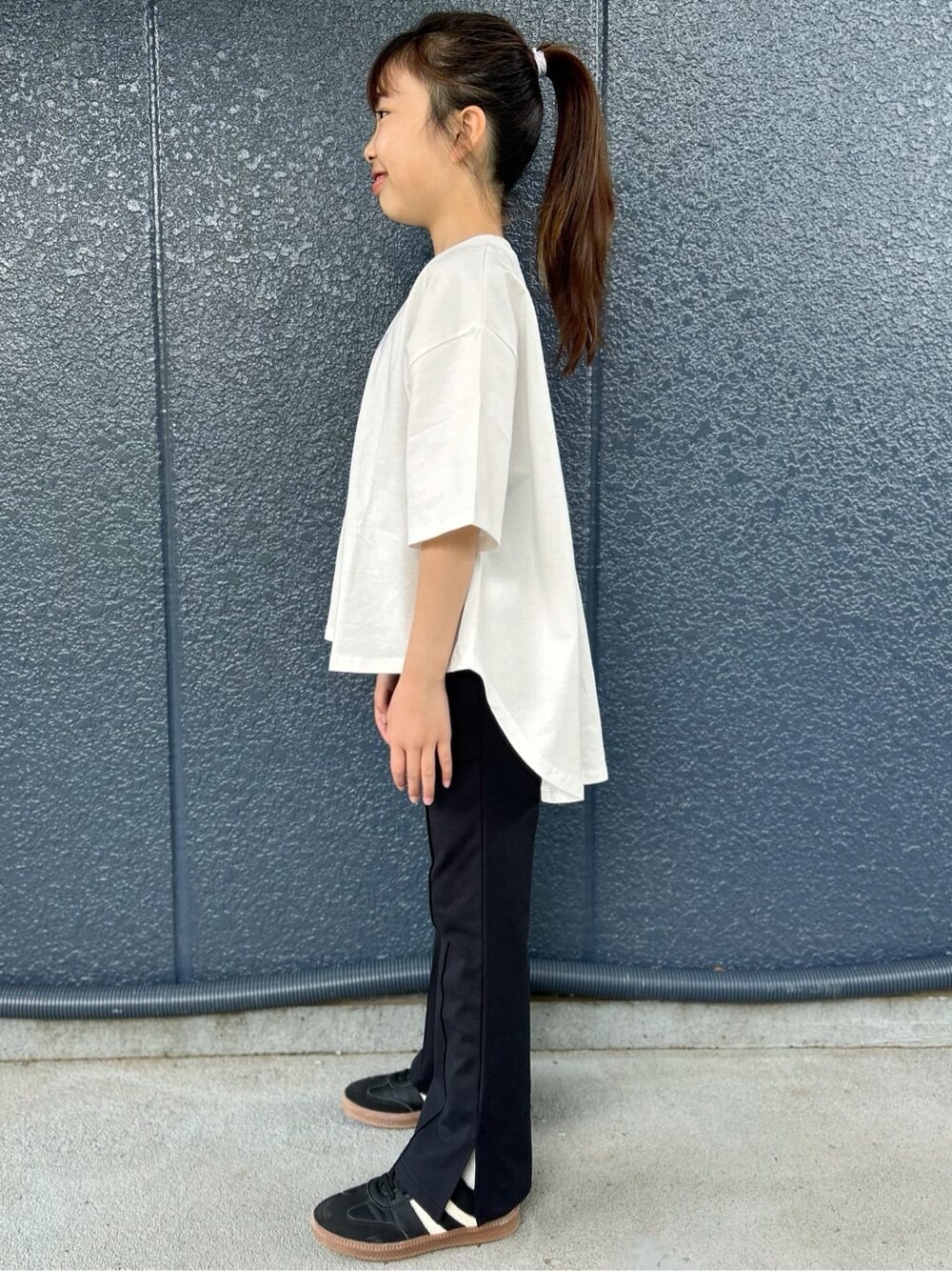 ホワイト系のTシャツ/カットソー、ブラック系のその他パンツ、シルバー系のショルダーバッグを着用したキッズの春コーディネートの3枚目の写真