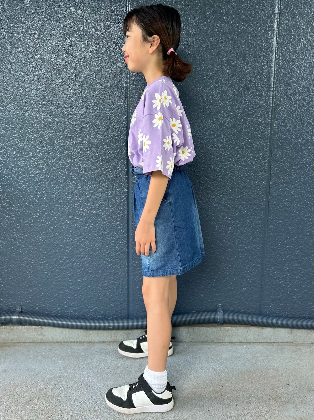 パープル系のTシャツ/カットソー、ブルー系のデニムスカートを着用したキッズの夏コーディネートの2枚目の写真