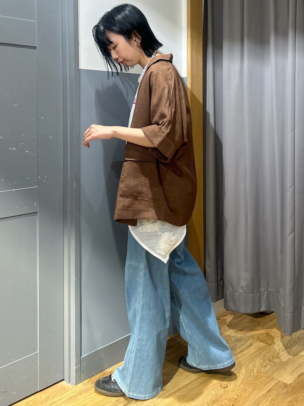 ブラウン系のテーラードジャケット、ブラック系のショルダーバッグ、グレー系のTシャツ/カットソーを着用したレディースの春コーディネートの2枚目の写真