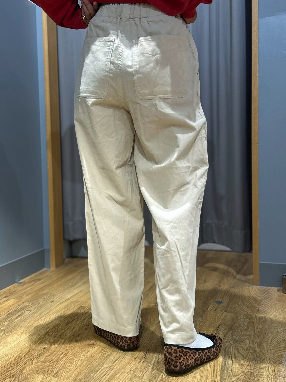 レッド系のスウェット、ホワイト系のその他パンツ、ブラウン系のバックパック/リュックを着用したレディースの秋コーディネートの6枚目の写真