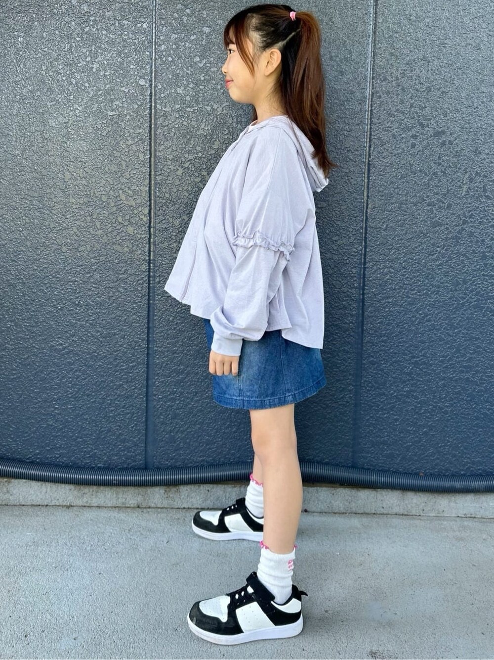 ピンク系のTシャツ/カットソー、ブルー系のデニムスカート、パープル系のパーカーを着用したキッズの春コーディネートの2枚目の写真