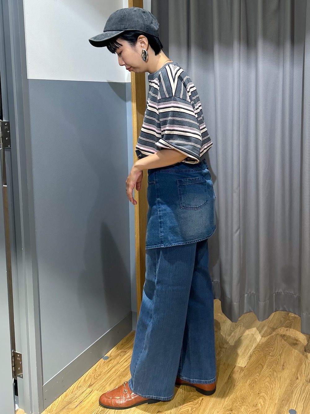 グレー系のTシャツ/カットソー、ブルー系のデニムパンツ、ベージュ系のトートバッグを着用したレディースの夏コーディネートの2枚目の写真
