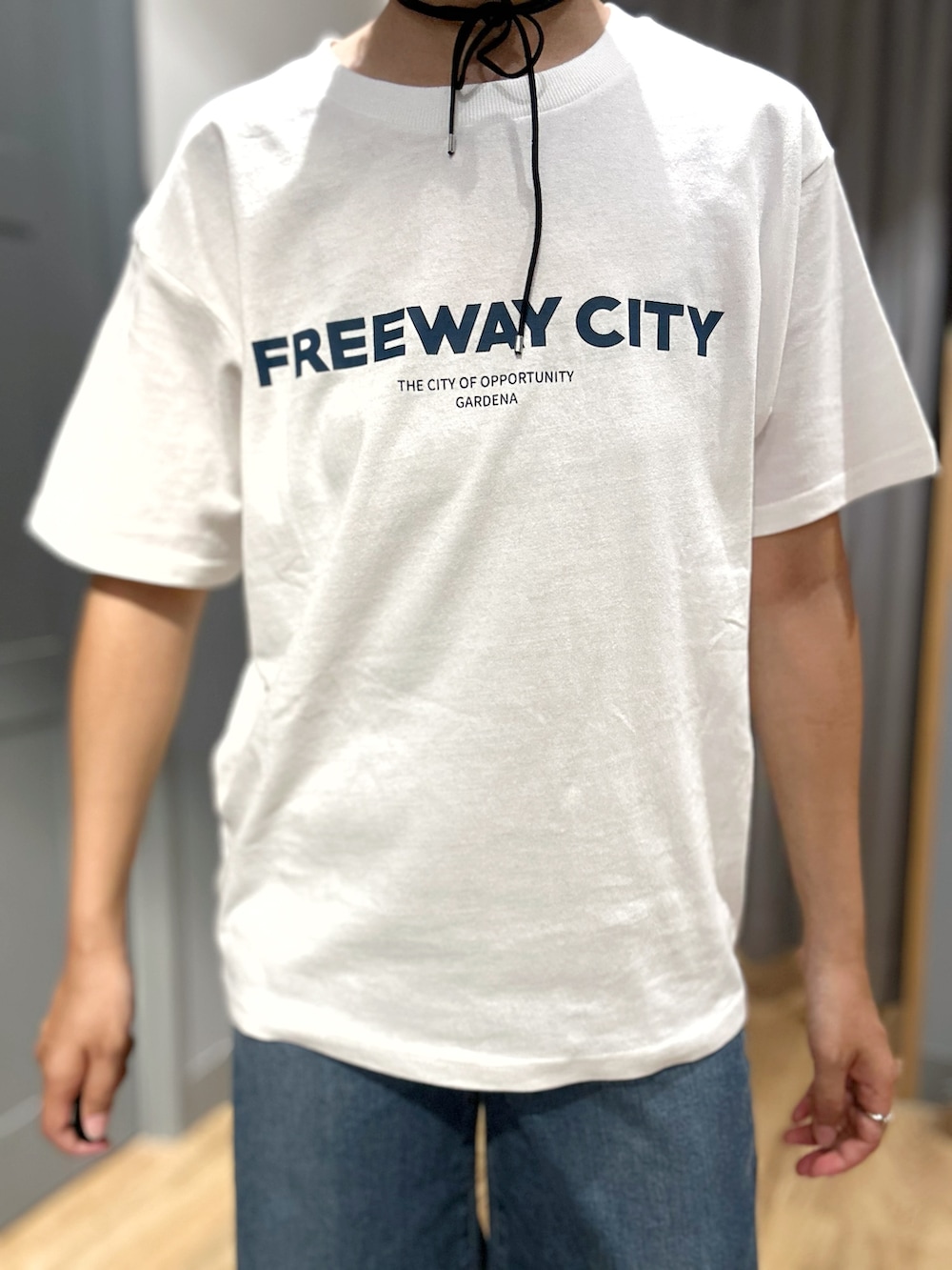 ホワイト系のTシャツ/カットソー、ブラック系のベスト、ブルー系のデニムパンツを着用したレディースの夏コーディネートの5枚目の写真