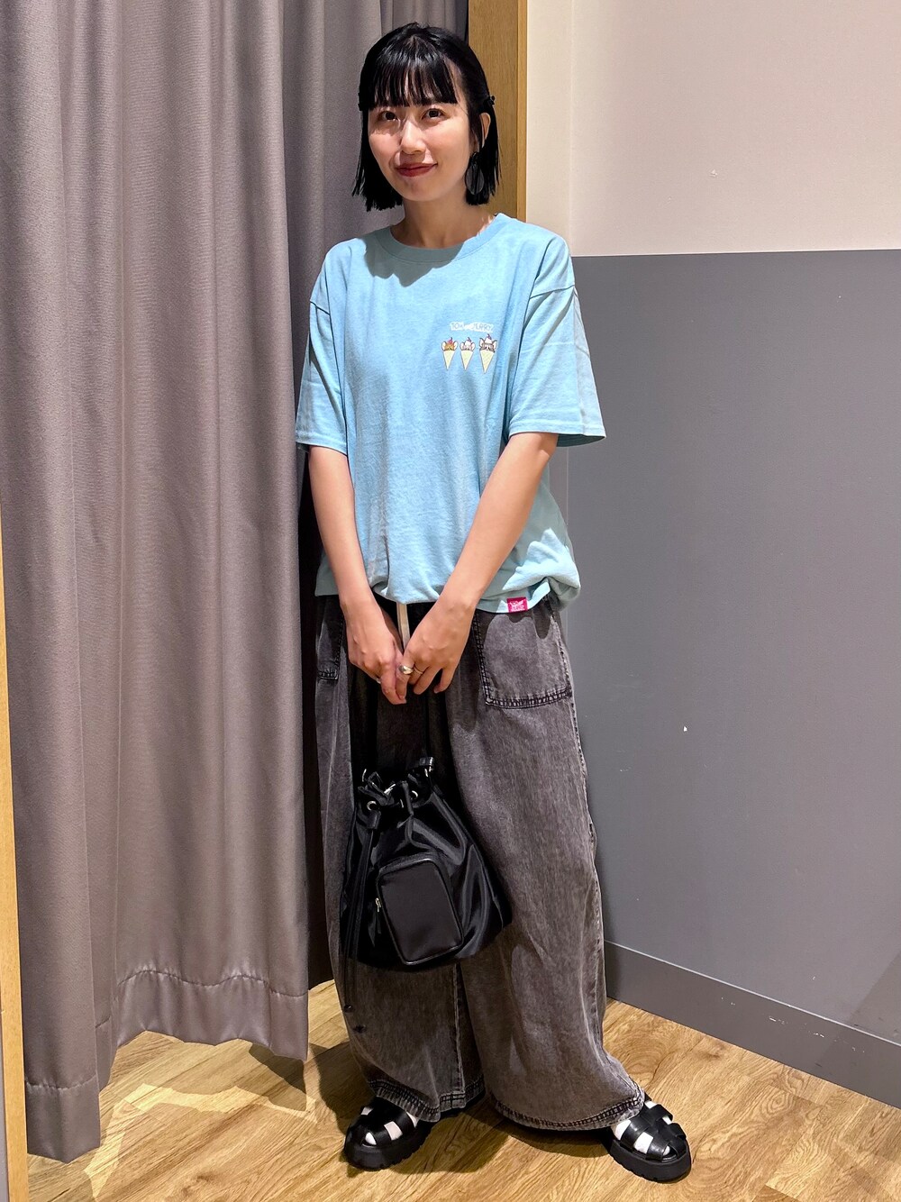ブルー系のTシャツ/カットソー、ブラック系のデニムパンツ、ブラック系のショルダーバッグを着用したレディースの夏コーディネートの2枚目の写真